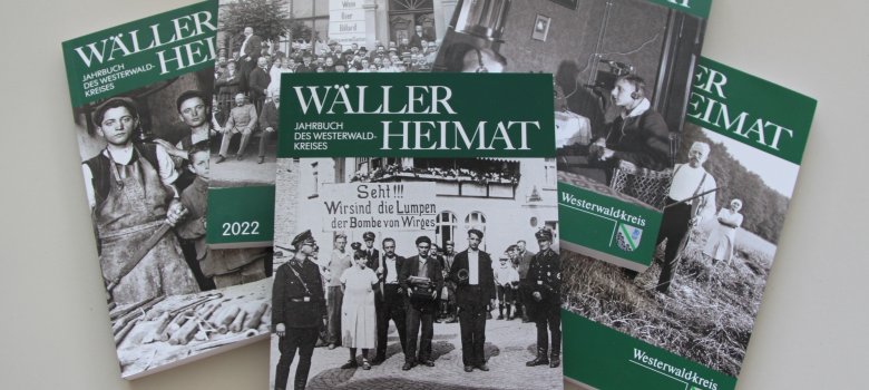 Verschiedene Ausgaben der Wäller Heimat liegen auf einem Tisch übereinander.