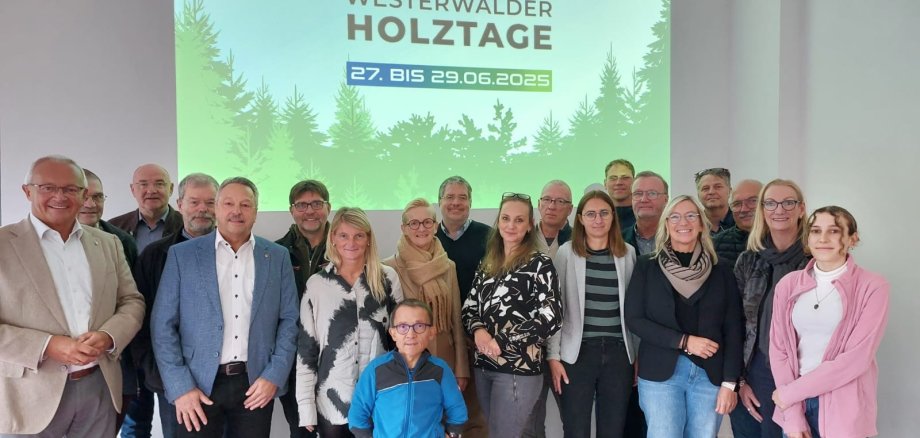 Eine große Gruppe Menschen steht vor einer Präsentationsleinwand der Westerwälder Holztage.