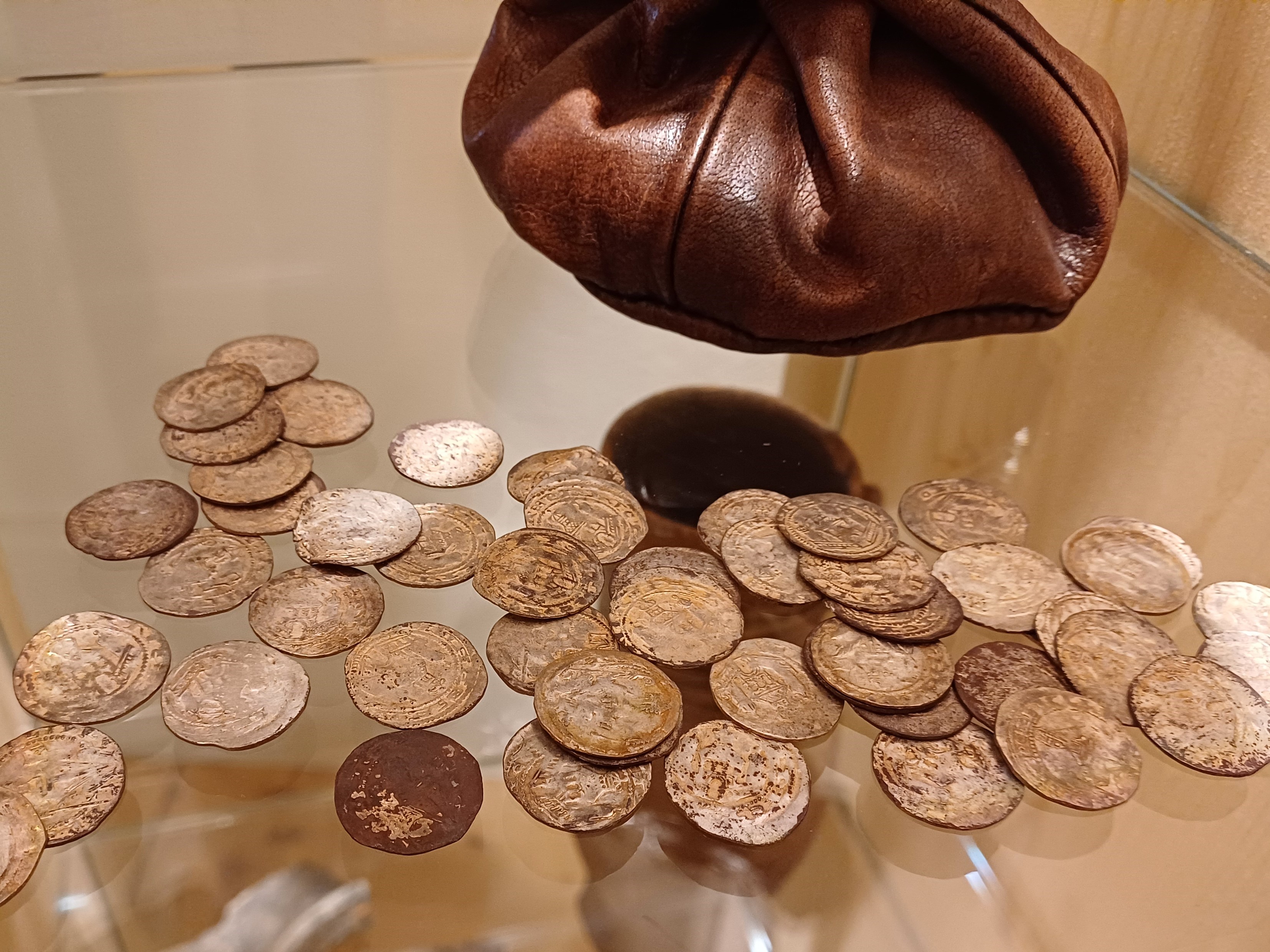 In Montabaur wurden Silbermünzen gefunden. Zahlreiche dieser Münzen liegen auf einem Glastisch. Sie bereichern derzeit eine Dauerausstellung des Landschaftsmuseums in Hachenburg. 