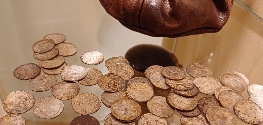 In Montabaur wurden Silbermünzen gefunden. Zahlreiche dieser Münzen liegen auf einem Glastisch. Sie bereichern derzeit eine Dauerausstellung des Landschaftsmuseums in Hachenburg.