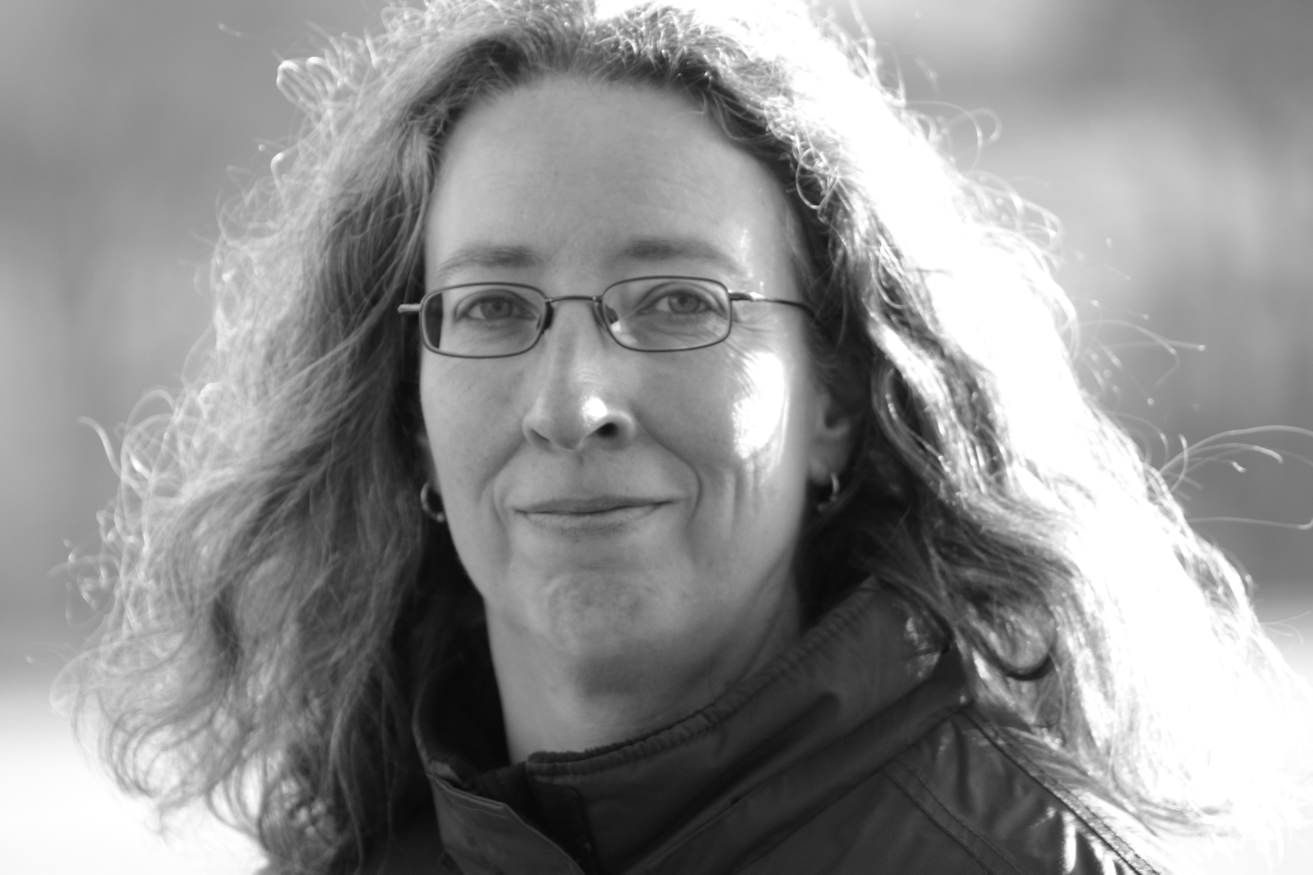 Die Autorin Annette Spratte lächelt in die Kamera. Es ist ein schwarz-weiß Portrait. 