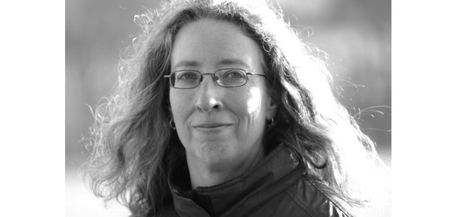 Die Autorin Annette Spratte lächelt in die Kamera. Es ist ein schwarz-weiß Portrait.