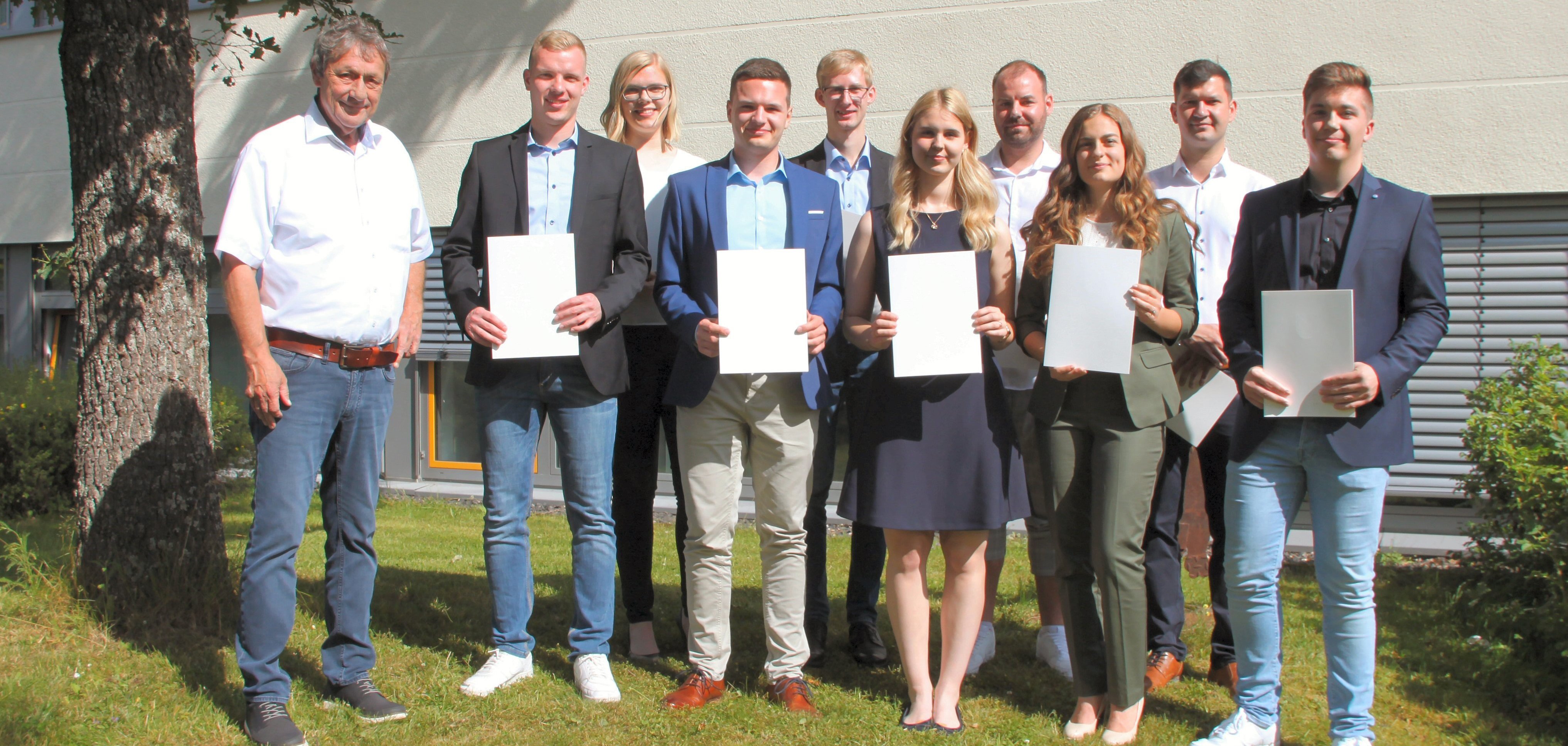 Landrat Achim Schwickert, links im Bild, freut sich mit den jungen Nachwuchskräften vor dem Verwaltungsgebäude.