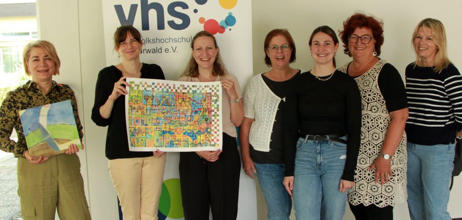 Sieben Frauen stehen vor einem RollUp der Volkshochschule.