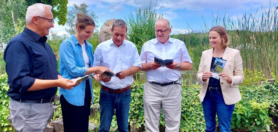Fünf Personen blättern in der neuen Broschüre.