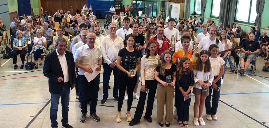 Landrat Achim Schwickert, Musikschullehrerinnen und -lehrer sowie Schülerinnen und Schüler stehen vor dem Publikum des Sommerfestes.