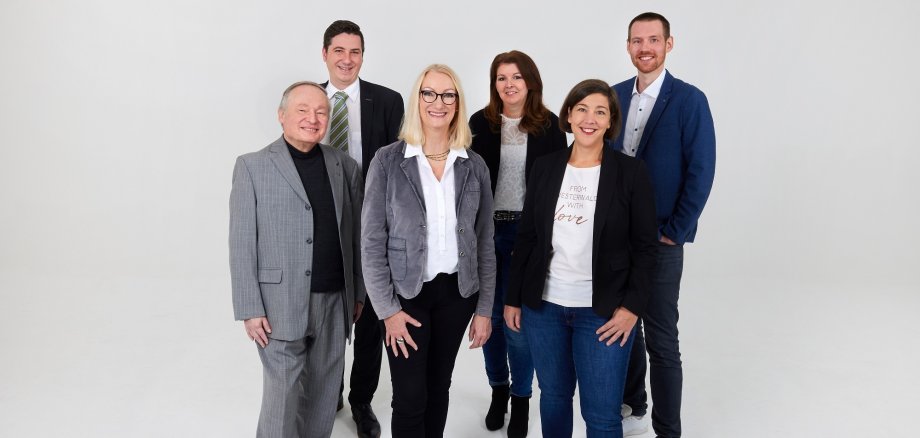 Drei Männer und drei Frauen haben sich für ein Gruppenfoto aufgestellt.