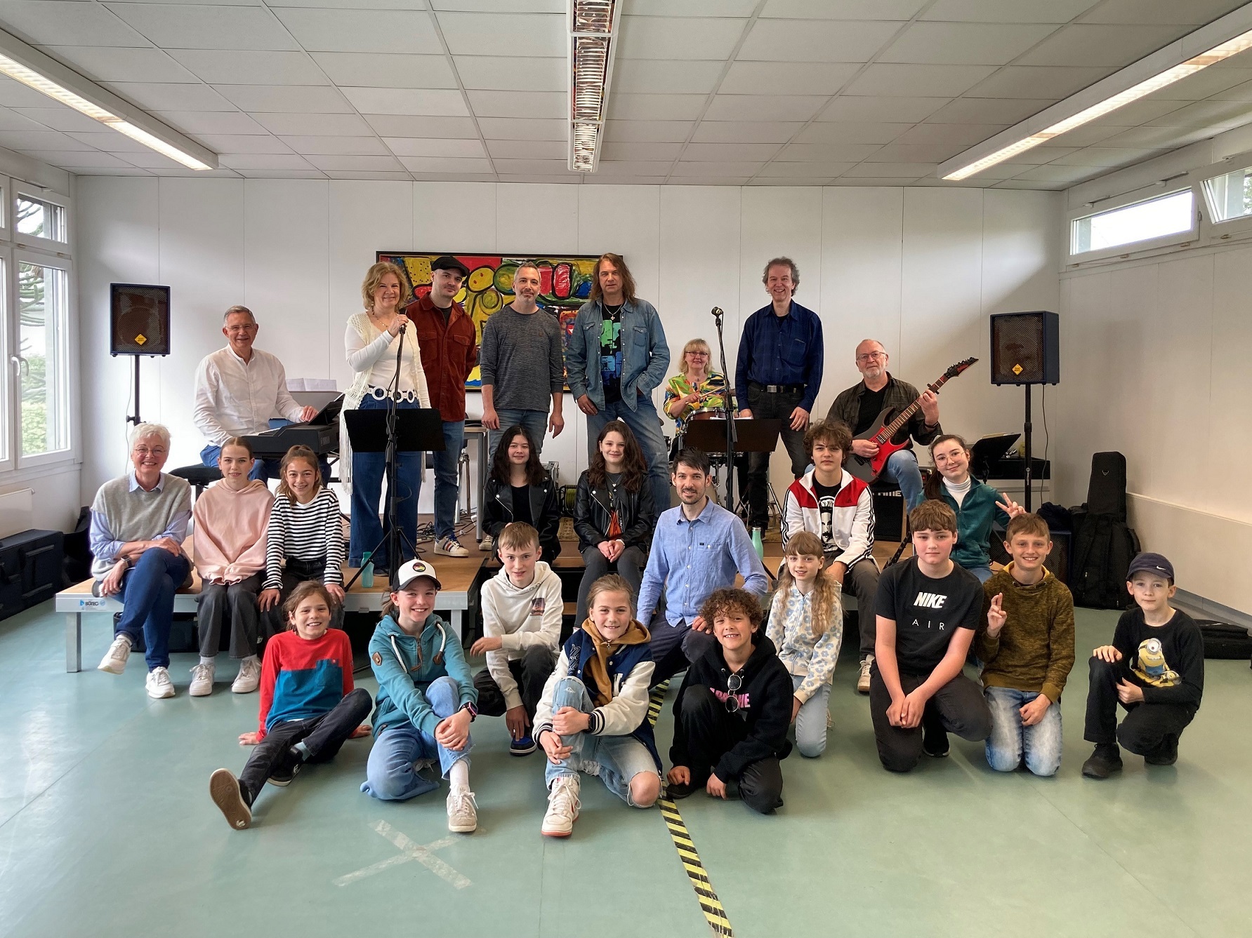 Musizierende verschiedener Altersgruppen haben sich zum Teil mit Instrumenten für ein Gruppenfoto aufgestellt.