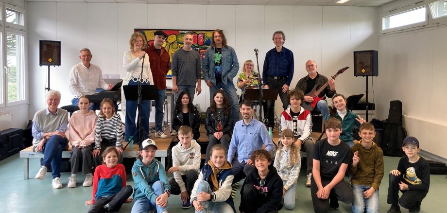 Musizierende verschiedener Altersgruppen haben sich zum Teil mit Instrumenten für ein Gruppenfoto aufgestellt.