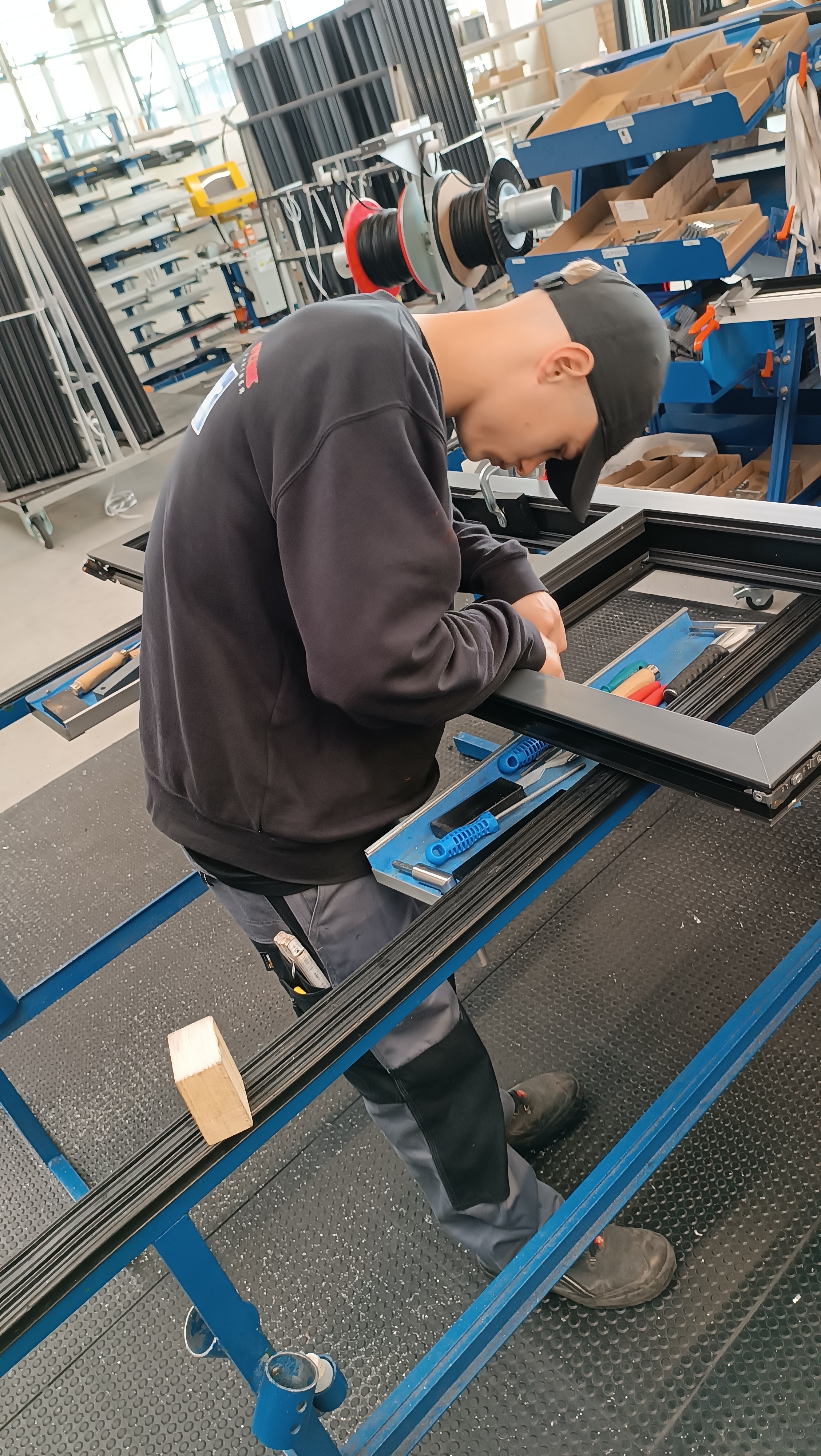 Ein junger Mann arbeitet konzentriert in einem Metallbauunternehmen.