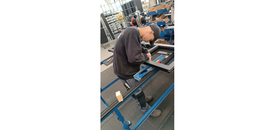 Ein junger Mann arbeitet konzentriert in einem Metallbauunternehmen.