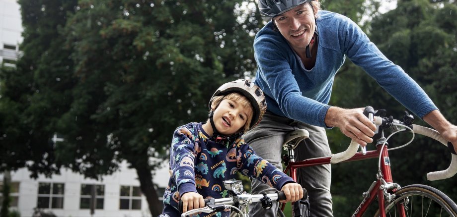 Ein Erwachsener und ein Kind sitzen auf ihrem Fahrrad