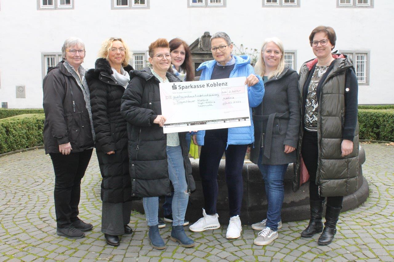 Ein großer Spendenscheck im Wert von 2.220 Euro wird an das Frauenhaus in Koblenz übergeben. 