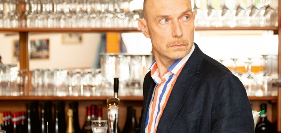 Portrait von Eric Pfeil an einer Theke.