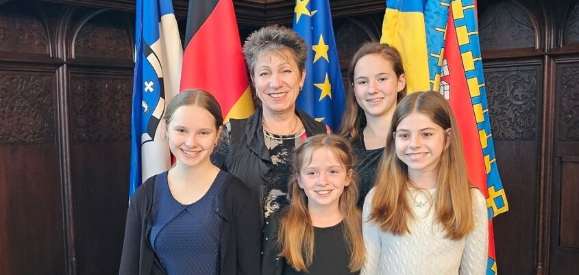 Vier Schülerinnen mit ihrer Lehrerin im Saal des Rathauses der Landeshauptstadt Saarbrücken.