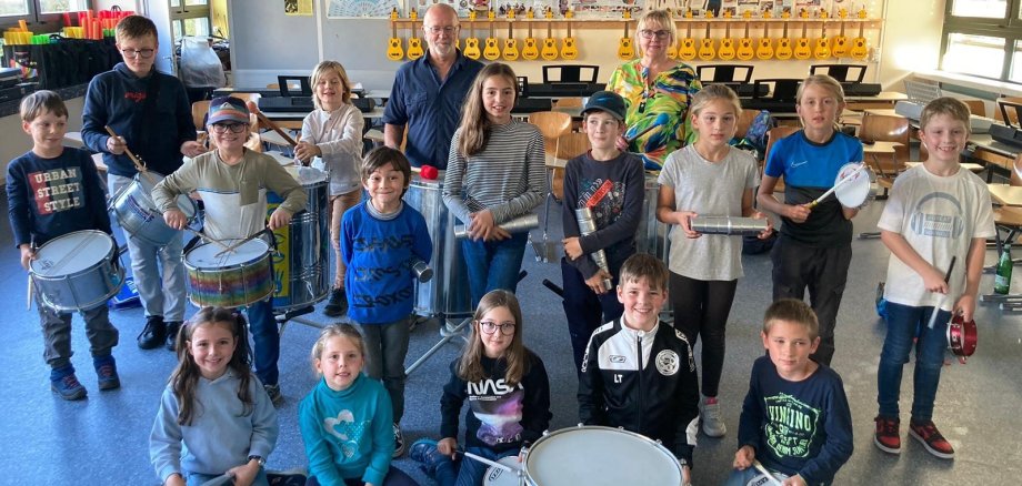Kinder und Erwachsene posieren mit ihren Trommeln für die Kamera.