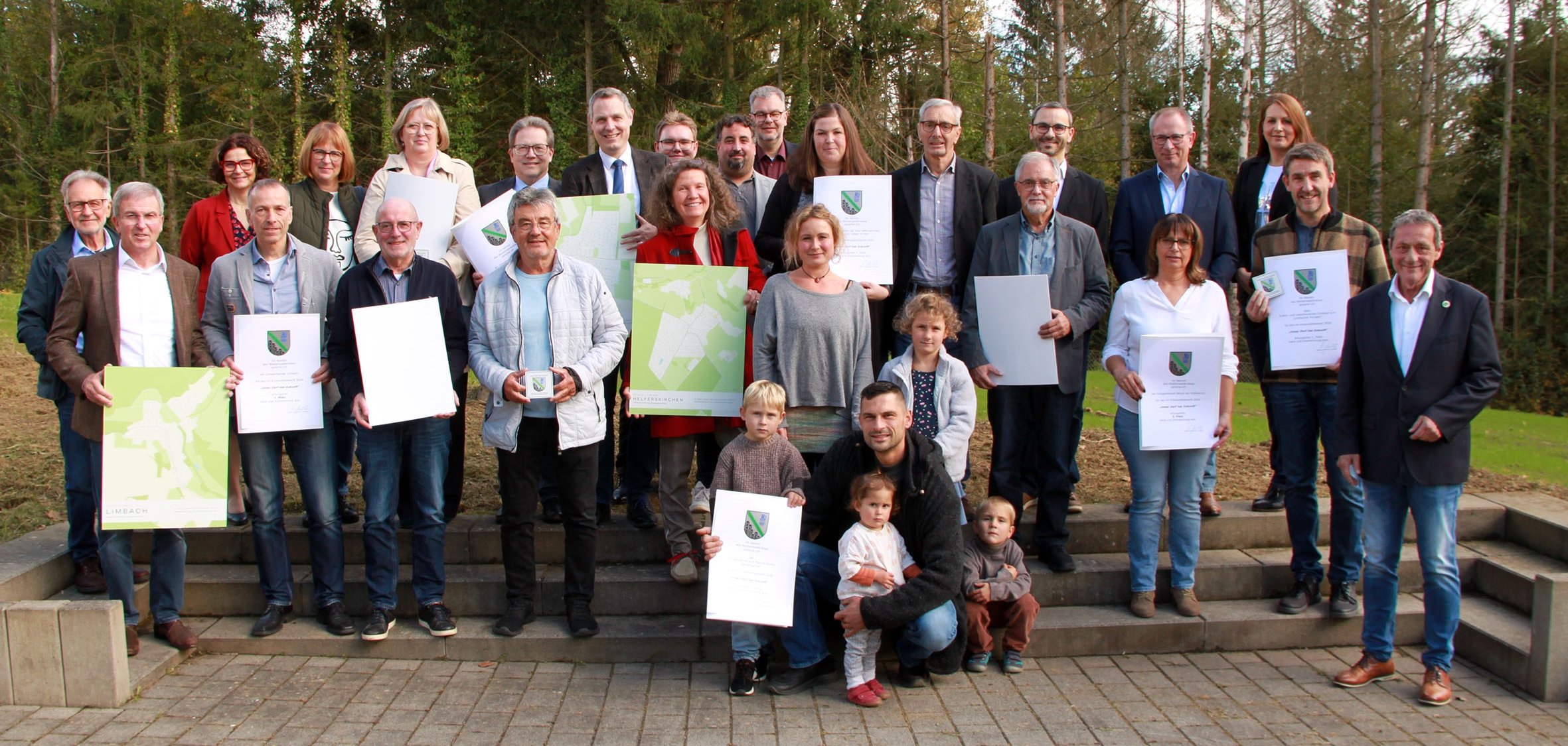 Die Gruppe der Sieger steht mit Landrat Achim Schwickert auf einer Treppe im Freien und präsentiert ihre Urkunden.