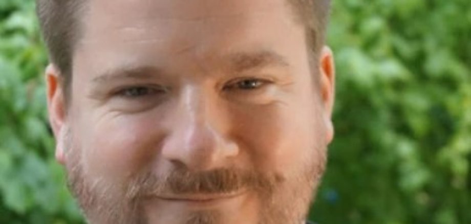 Alexander Solloch lacht in die Kamera.
