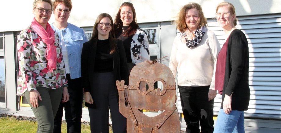 Sechs Frauen stehen neben einer winkenden Minion-Figur vorm Kreishaus.