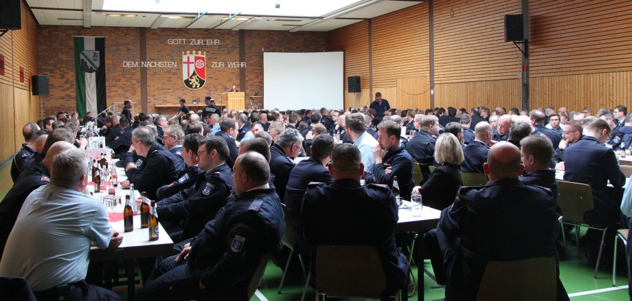 Die Sporthalle in Niederahr mit Blick auf die Bühne zeigt gut besetzte Plätze an den aufgestellten Tischen.