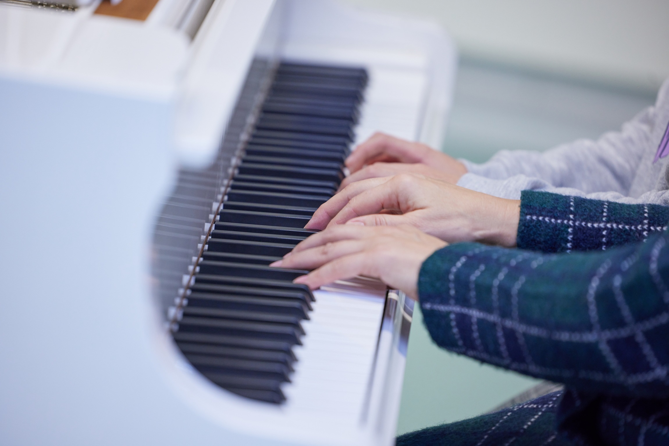 In einer Großaufnahme spielen vier Hände Klavier.