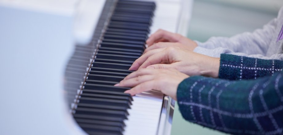 In einer Großaufnahme spielen vier Hände Klavier.