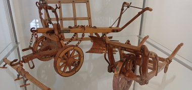 Ein detaillierter Modell-Pflug steht in einem Glaskasten.