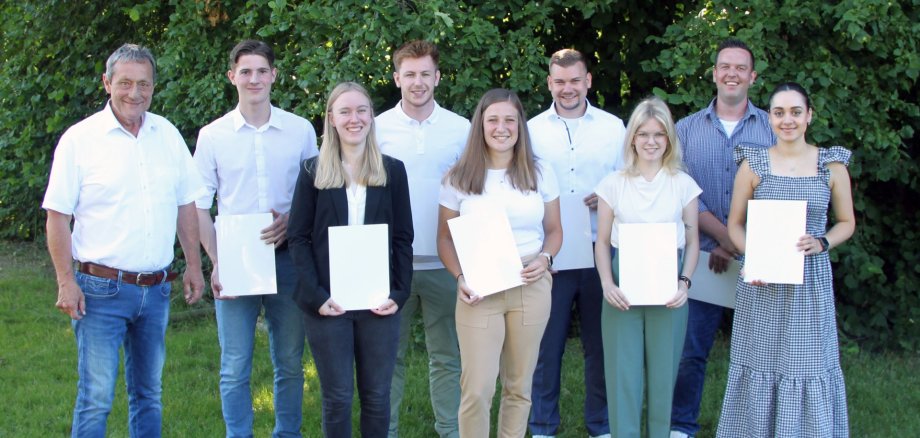 Neben Landrat Schwickert stehen im Grünen vier Mädchen und vier Jungen mit Urkunden in der Hand.