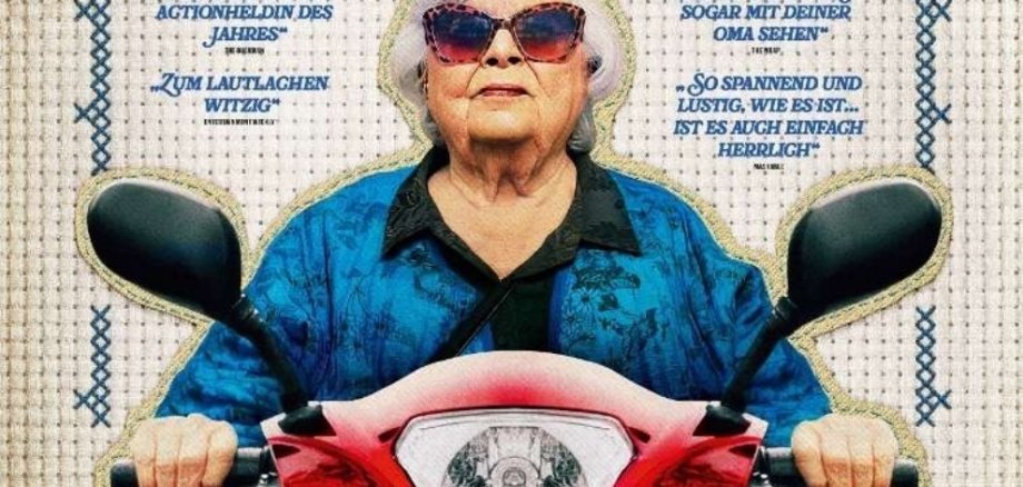 Eine ältere Frau mit weißen Haaren und Sonnenbrille fährt auf dem Filmplakat mit einem Motorroller.