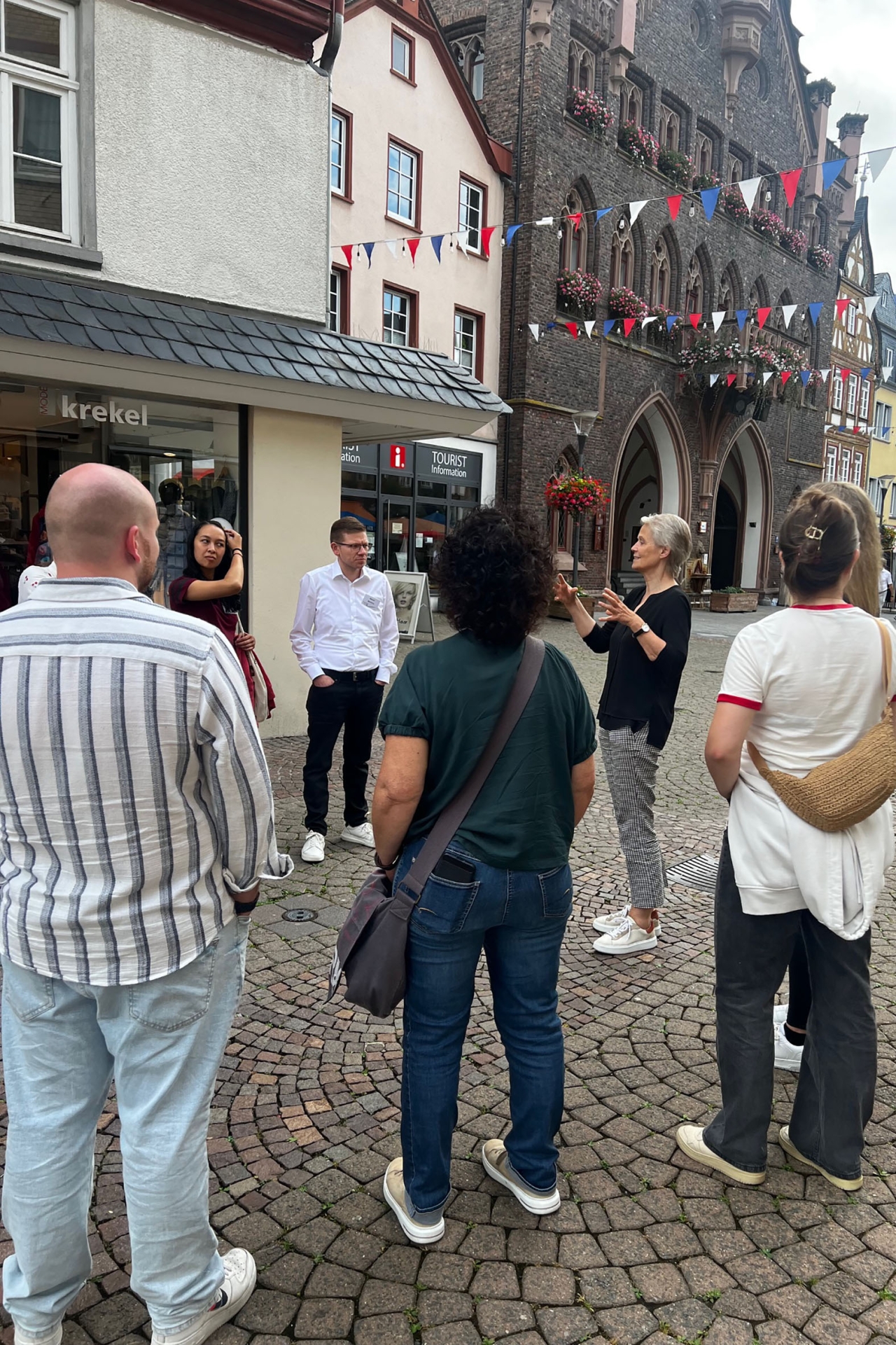 Eine Menschengruppe steht in der historischen Altstadt von Montabaur und hört der Ersten Kreisbeigeordneten Gabriele Wieland zu.
