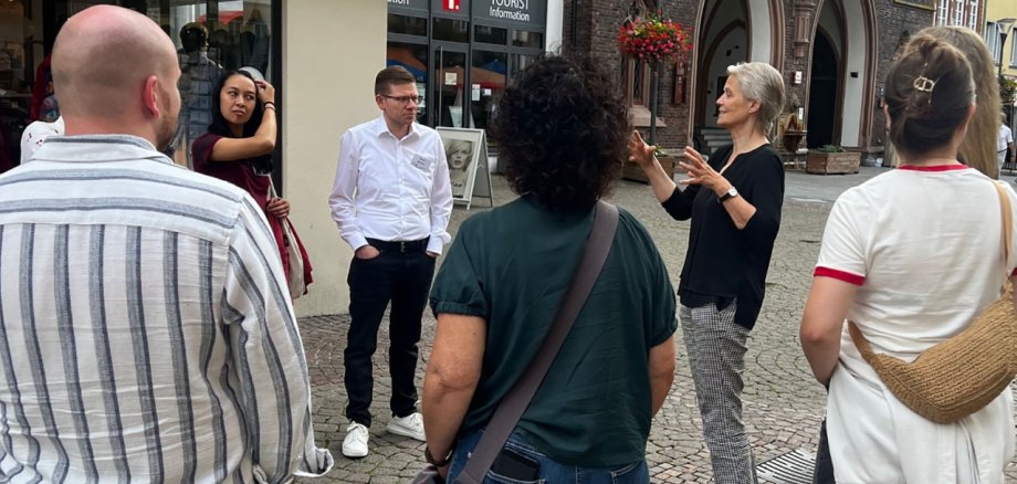 Eine Menschengruppe steht in der historischen Altstadt von Montabaur und hört der Ersten Kreisbeigeordneten Gabriele Wieland zu.