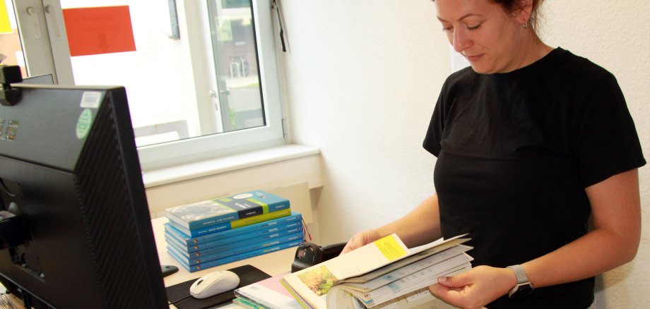 Eine Frau blättert in Schulbüchern.