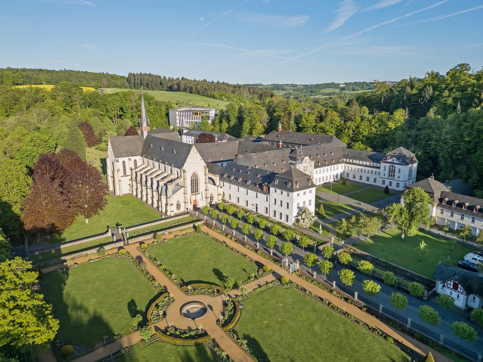 Das Kloster mit seinen diversen Bautrakten steht im Grünen und hat im Garten einen zentralen Platz, zu dem vier Wege führen.