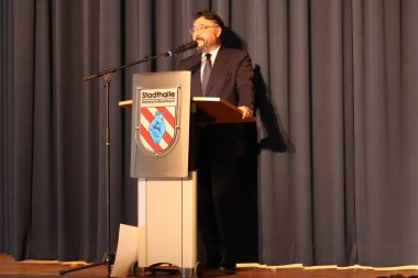 Herr Dolge spricht am Rednerpult auf der Bühne.