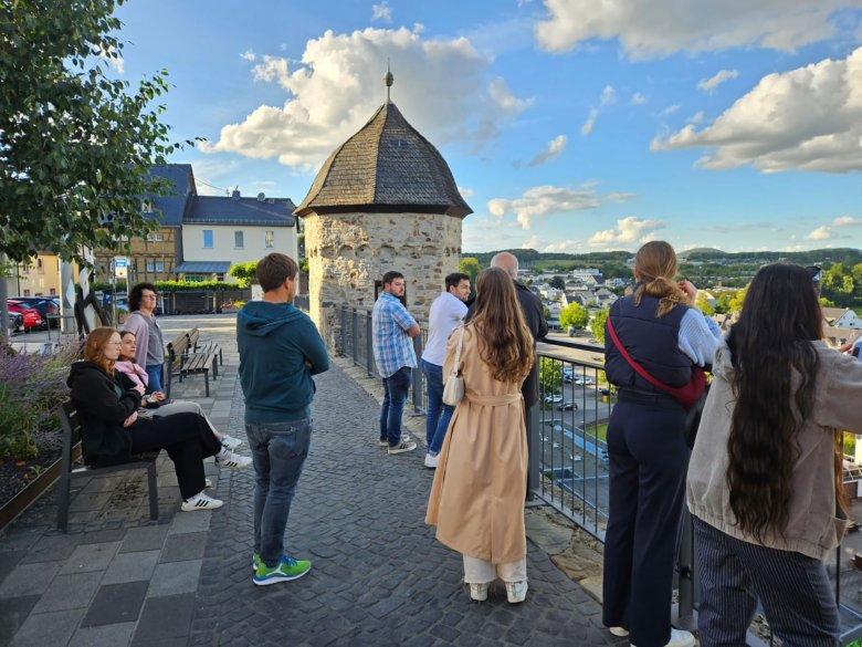 Eine Gruppe Studierender schaut vom Schloss Montabaur auf die Stadt.