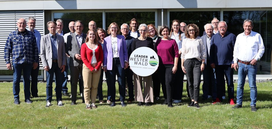Frauen und Männer stehen mit einem Schild "Leader Westerwald" auf einer Wiese.