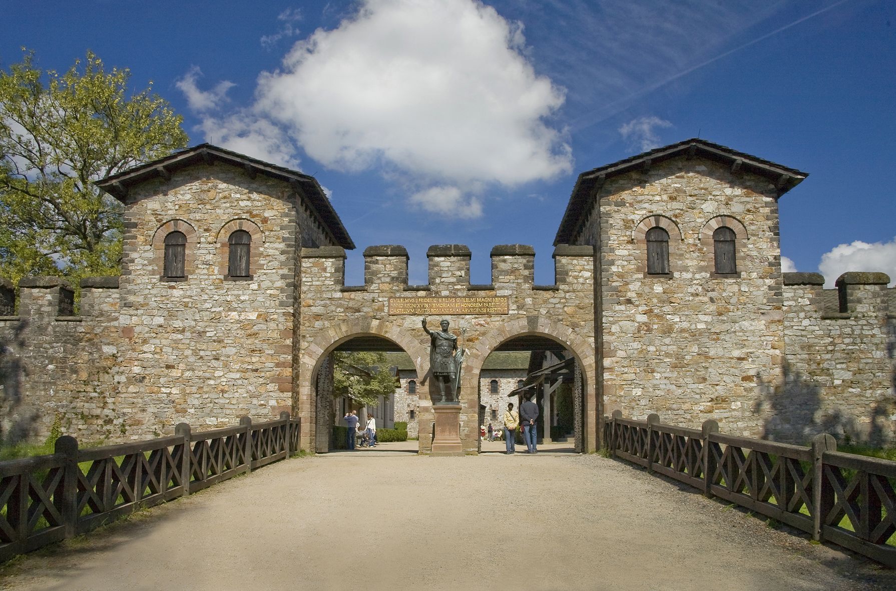 Eine alte Burg mit Zinnen vor blauem Himmel.