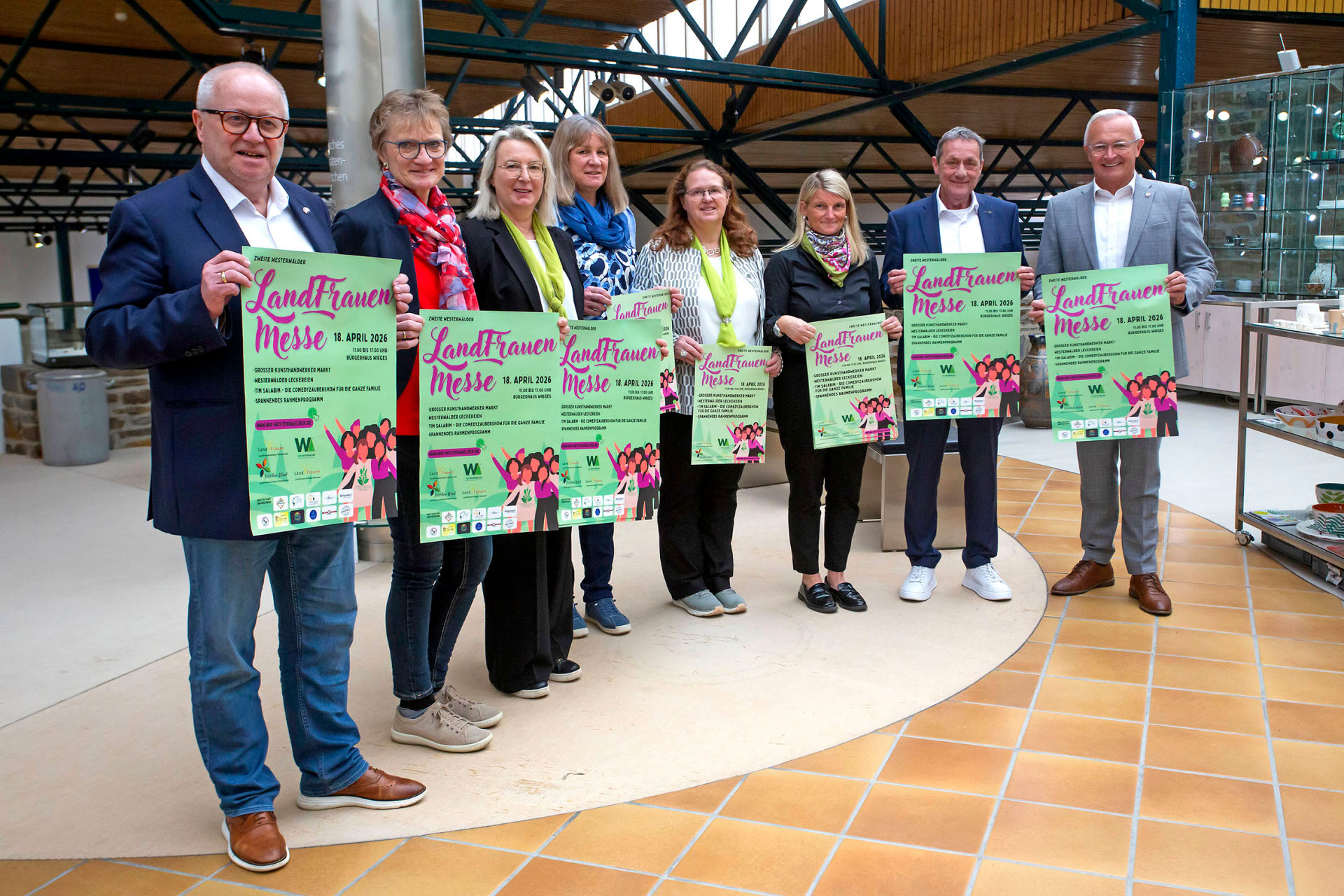 Frauen und Männer halten grüne Plakate mit der Aufschrift Landrauenmesse in der Hand.
