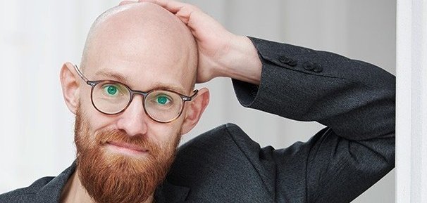 Ein Mann mit Glatze und rotem Vollbart
