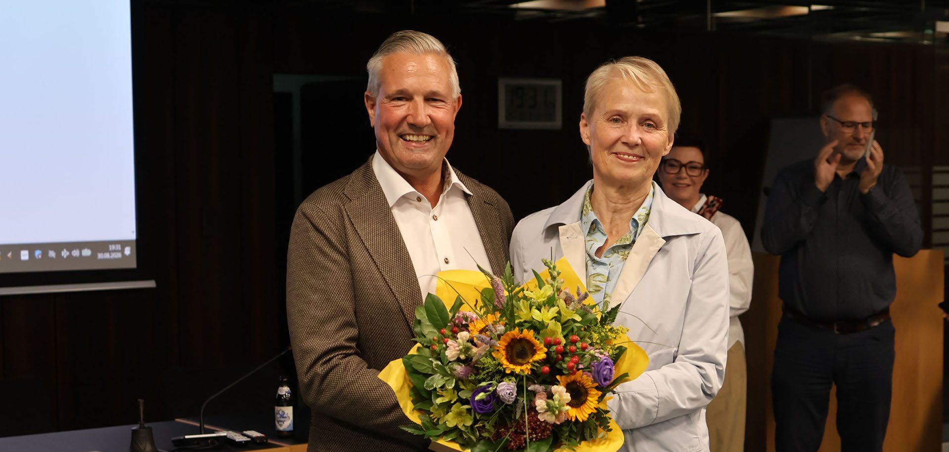 Gabriele Wieland überreicht Klaus Lütkefedder einen Blumenstrauß.