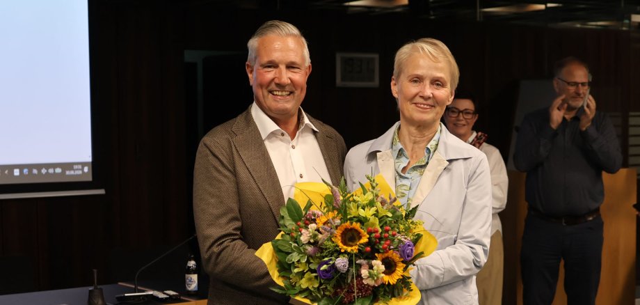 Gabriele Wieland überreicht Klaus Lütkefedder einen Blumenstrauß.