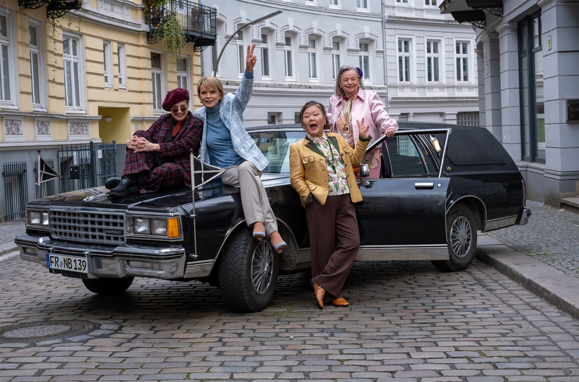 Vier Seniorinnen befinden sich an einem großen Auto.