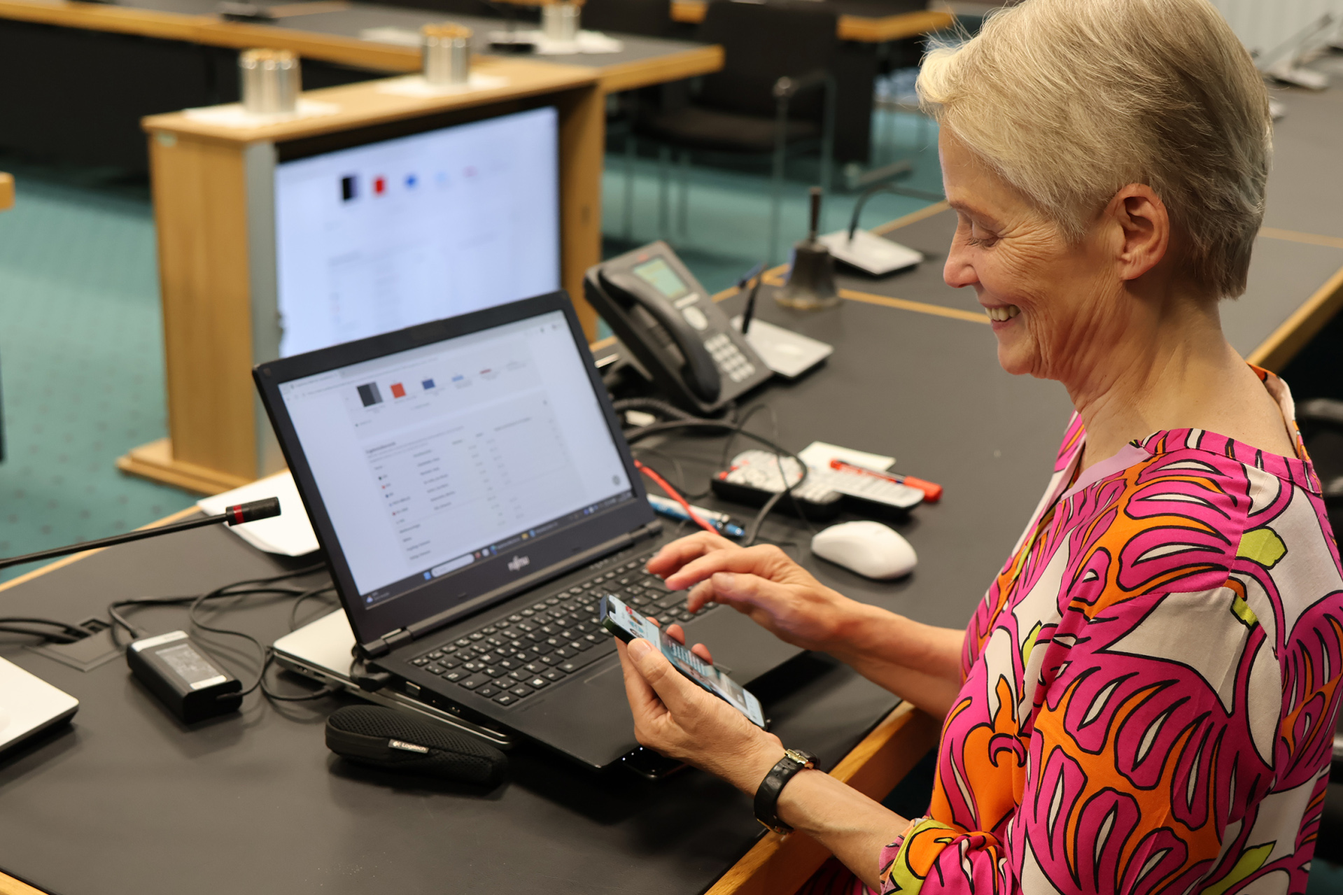 Eine Frau sitzt vor einem Laptop mit Grafiken.