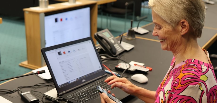 Eine Frau sitzt vor einem Laptop mit Grafiken.