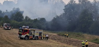 Auf einem Felo sind Feuerwehrleute und -fahrzeuge im Einsatz.