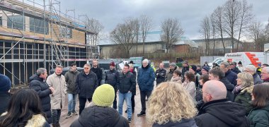 Viele Menschen stehen im Kreis um den Landrat, der eine Rede hält.