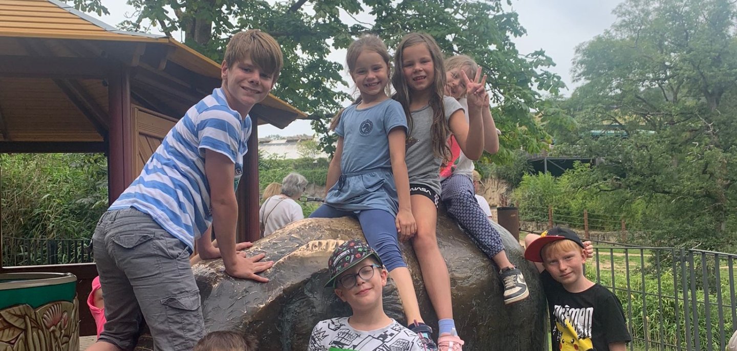 Auf einem Spielplatz klettern Kinder auf einem Dekoelefanten.