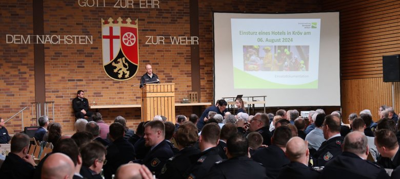 Feuerwehrleute schauen auf die Bühne.