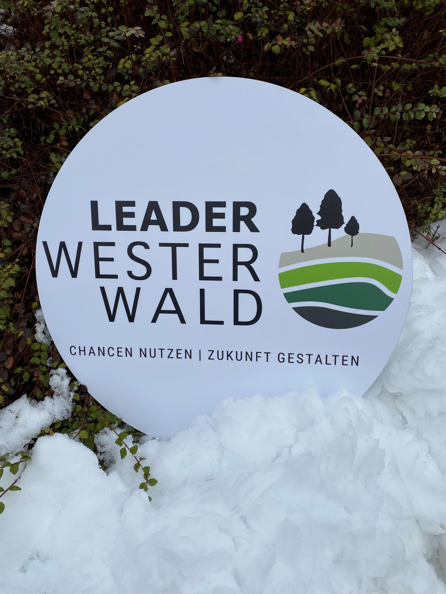 Ein Schild mit der Aufschrift LEADER Westerwald steht im Schnee.
