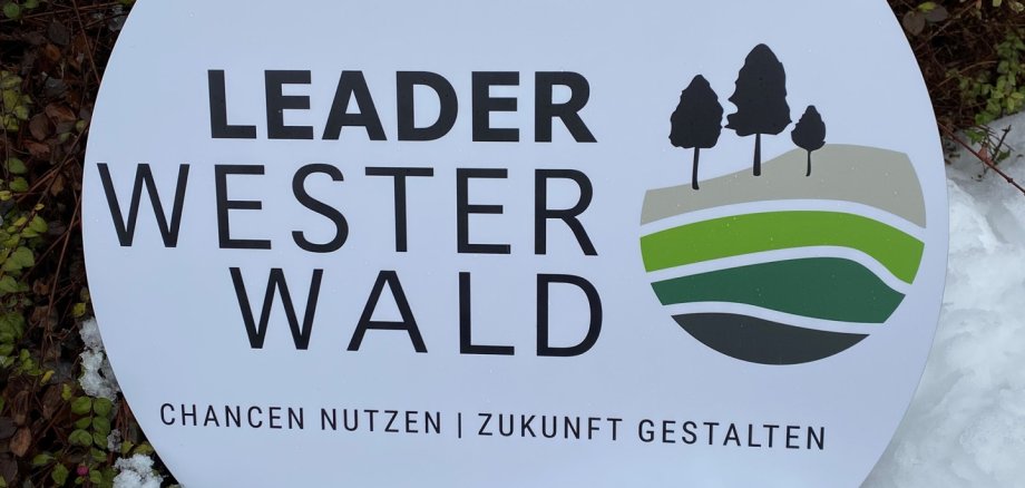 Ein Schild mit der Aufschrift LEADER Westerwald steht im Schnee.